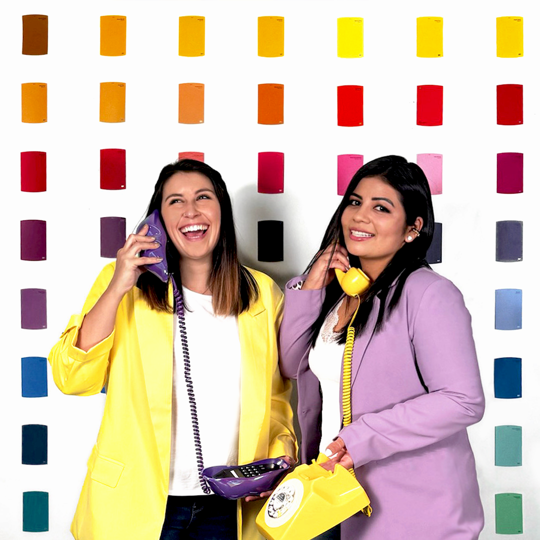 Andrea Hernandez and Raquel Aparicio of P&Y Studio Creativo, two women in colorful outfits on telephones